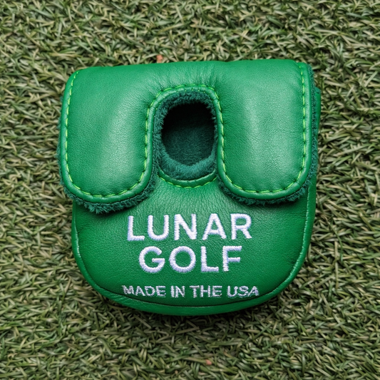 Green golf club head cover with 'Lunar Golf' branding on grass