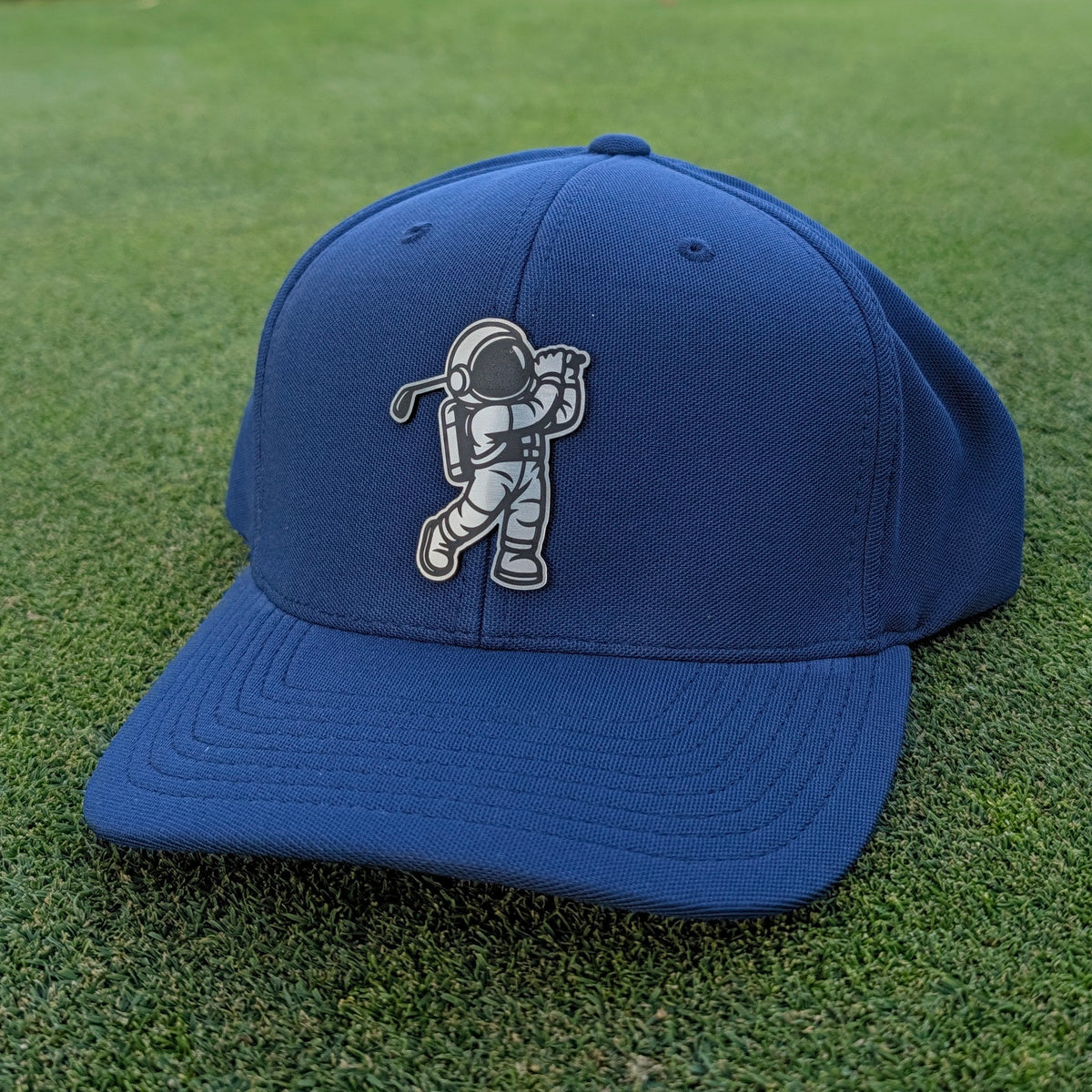 metal steel astronaut swinging a golf club on a navy blue golf hat