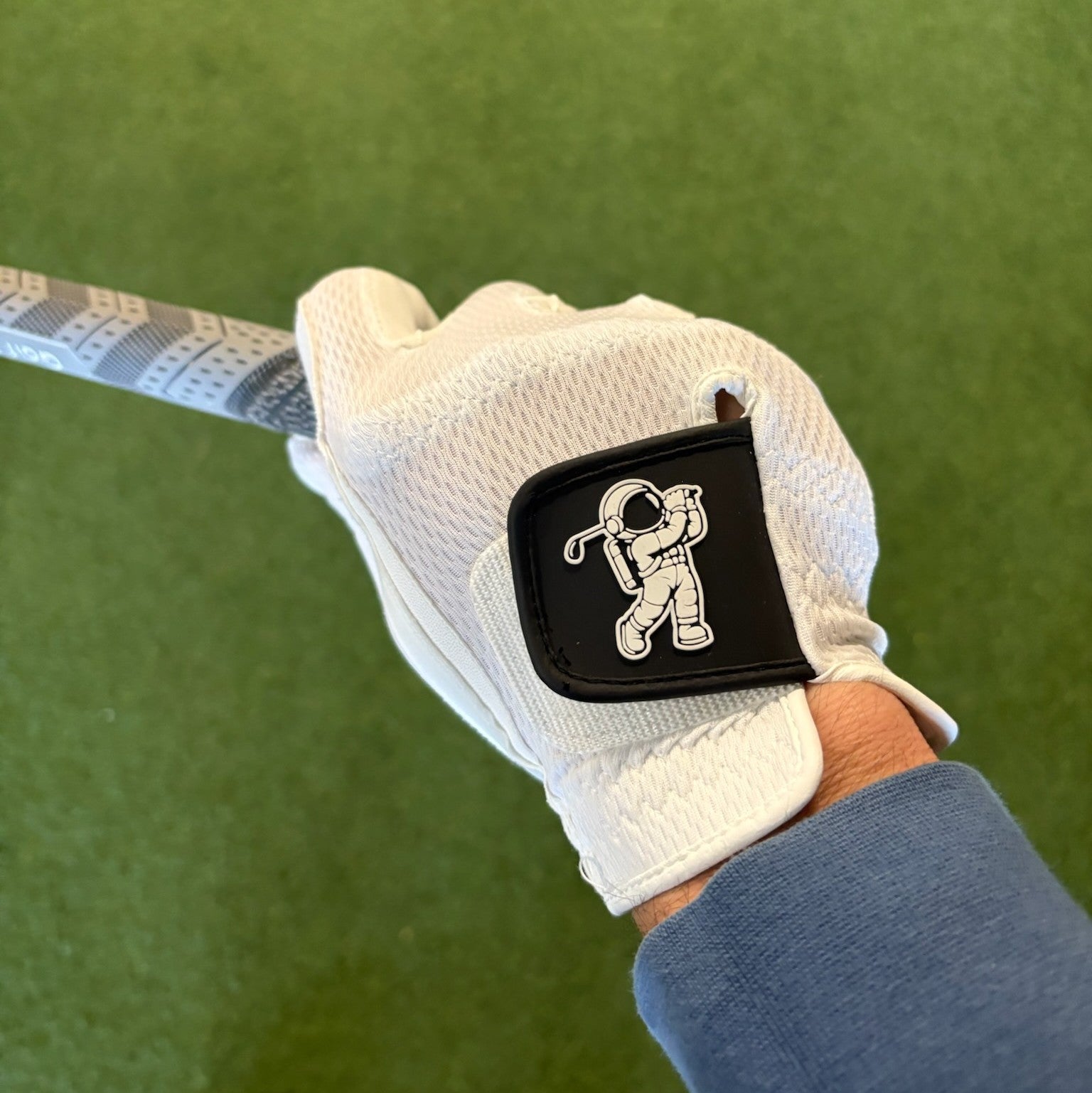 white lefty golf glove holding a golf grip